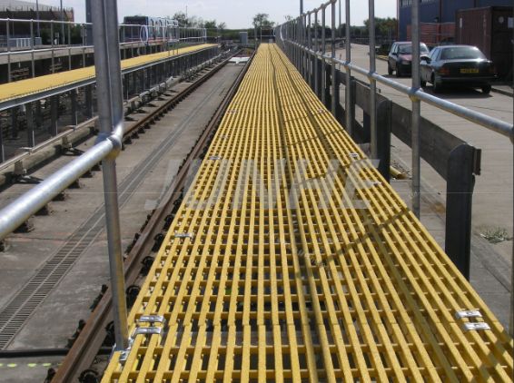 Yellow fiberglass grating walkway (railway/industrial area)